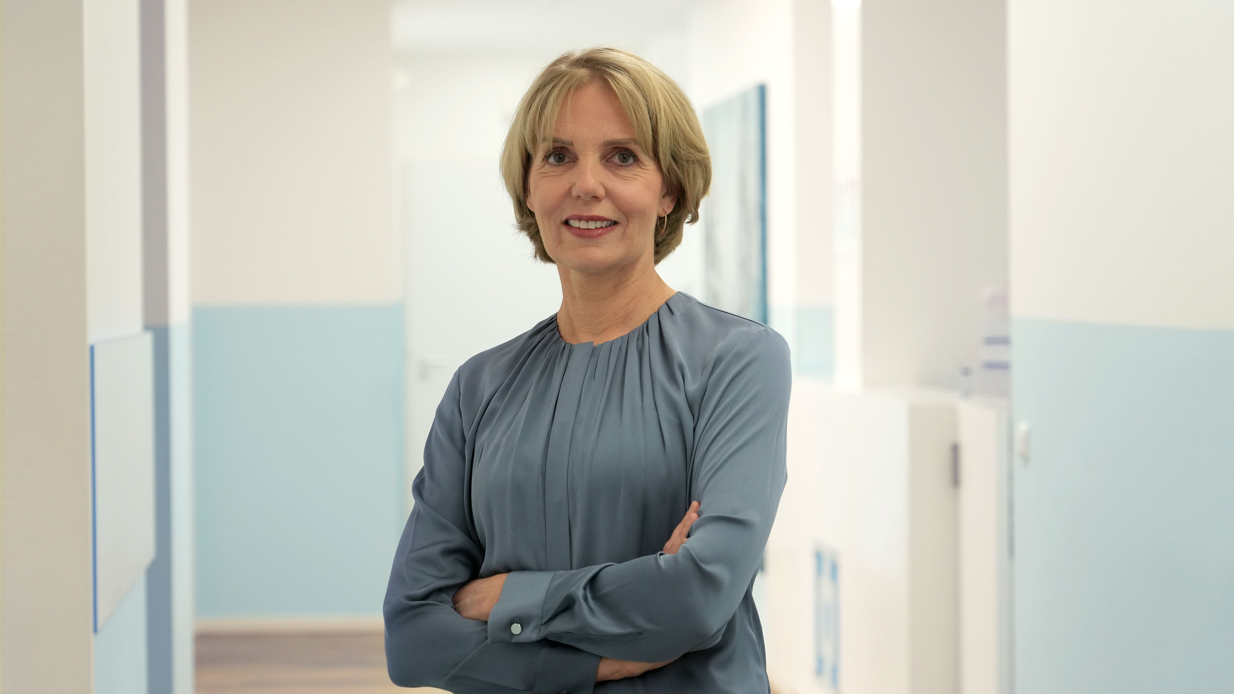 Freundliches Porträt der leitenden Ärztin Dr. med. Esther Bank-Weis im Praxisflur des Lungenzentrums Darmstadt