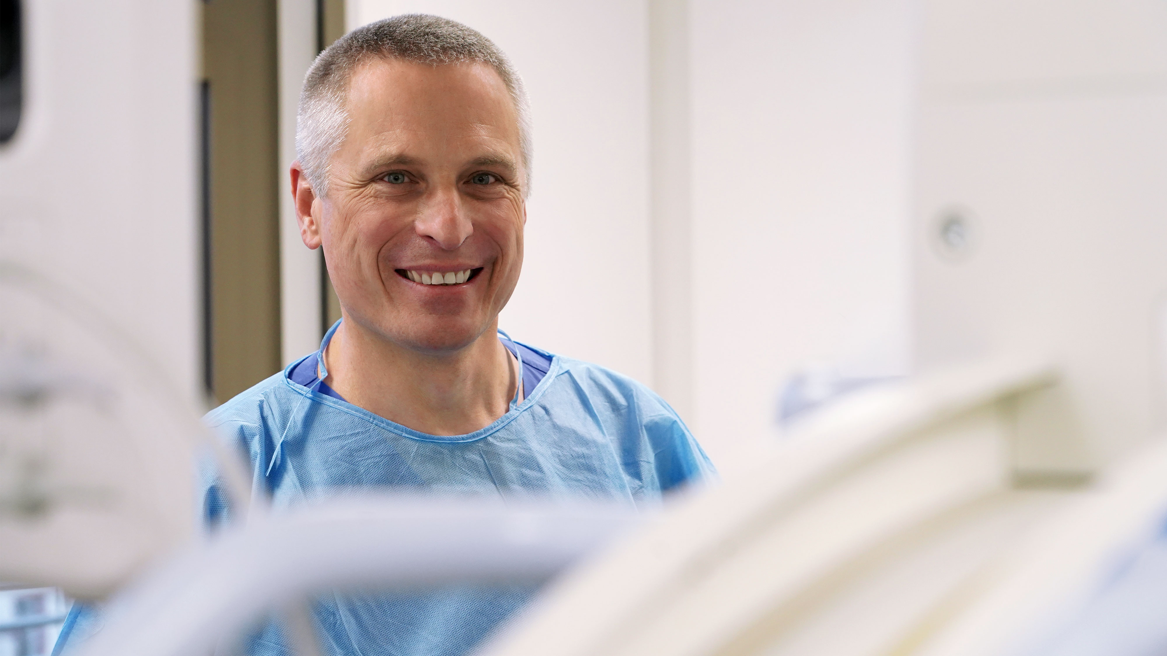 Freundliches Porträt (Nahaufname) von Dr. Konrad Kneser als Belegarzt in der Endoskopie-Einheit im Alice Hospital in Operationskleidung