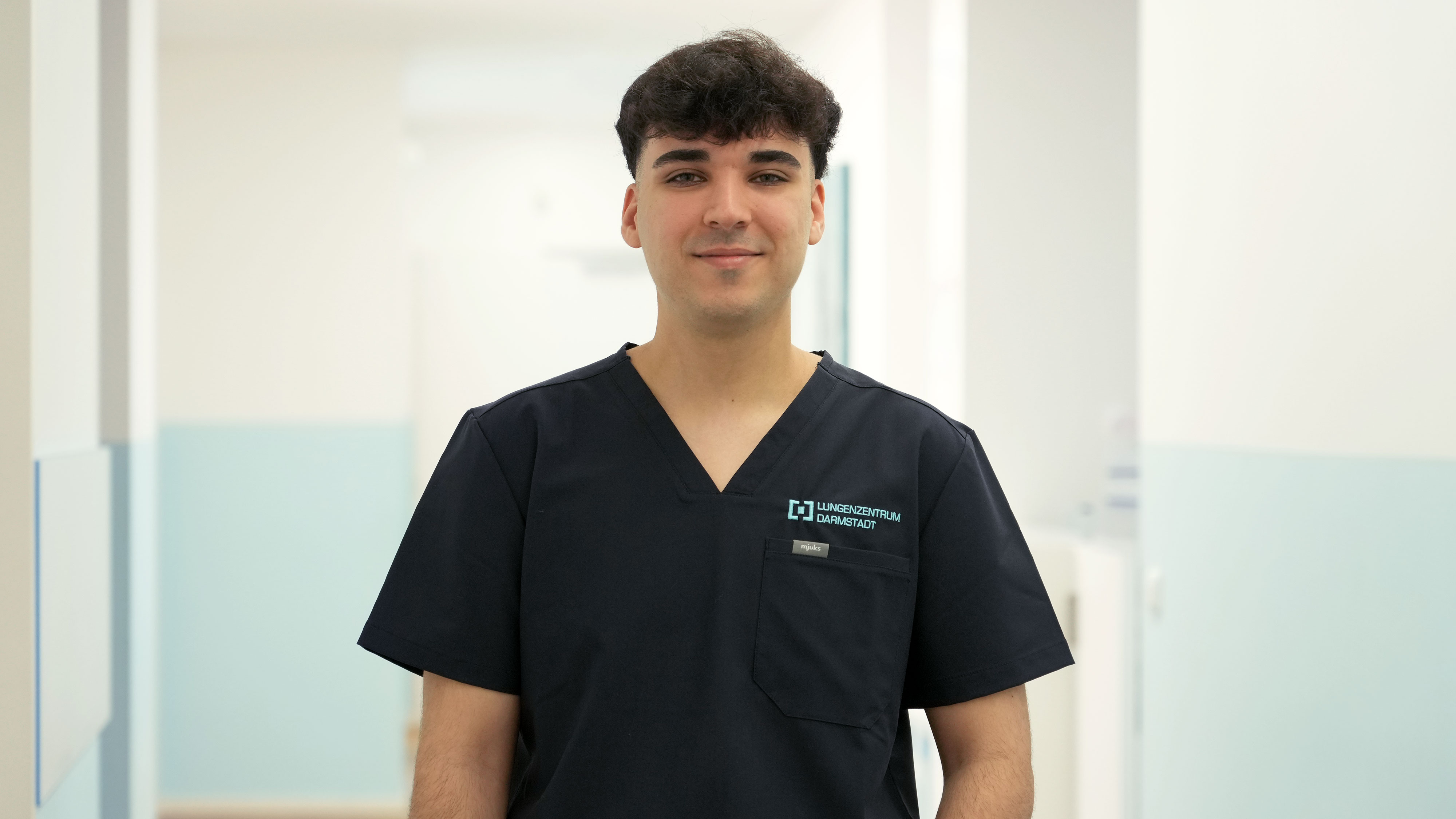 Porträt von Emre Tas im Praxis-Flur, Mitarbeiter im Lungenzentrum Darmstadt